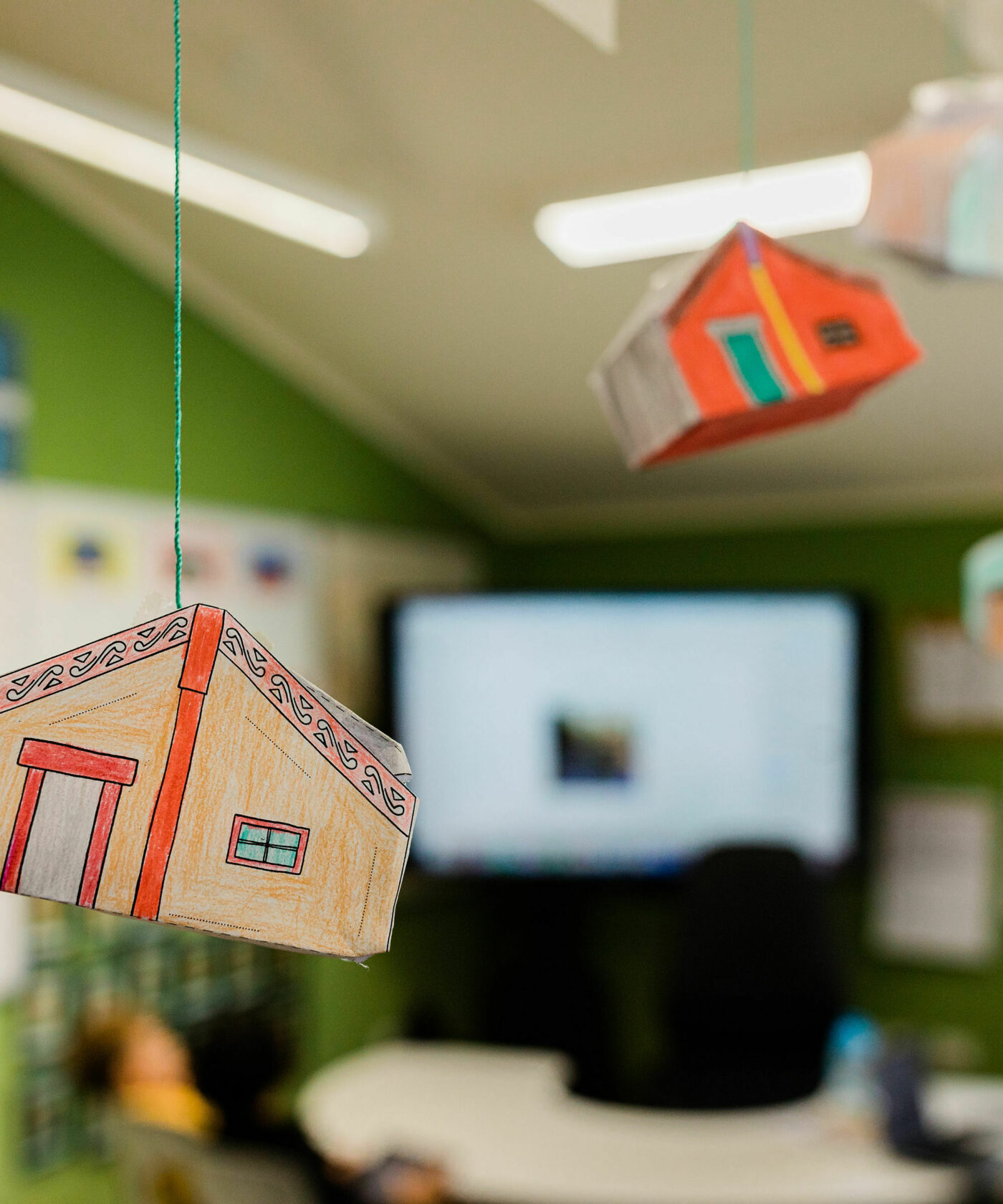 Paper marae suspended from the ceiling by string.