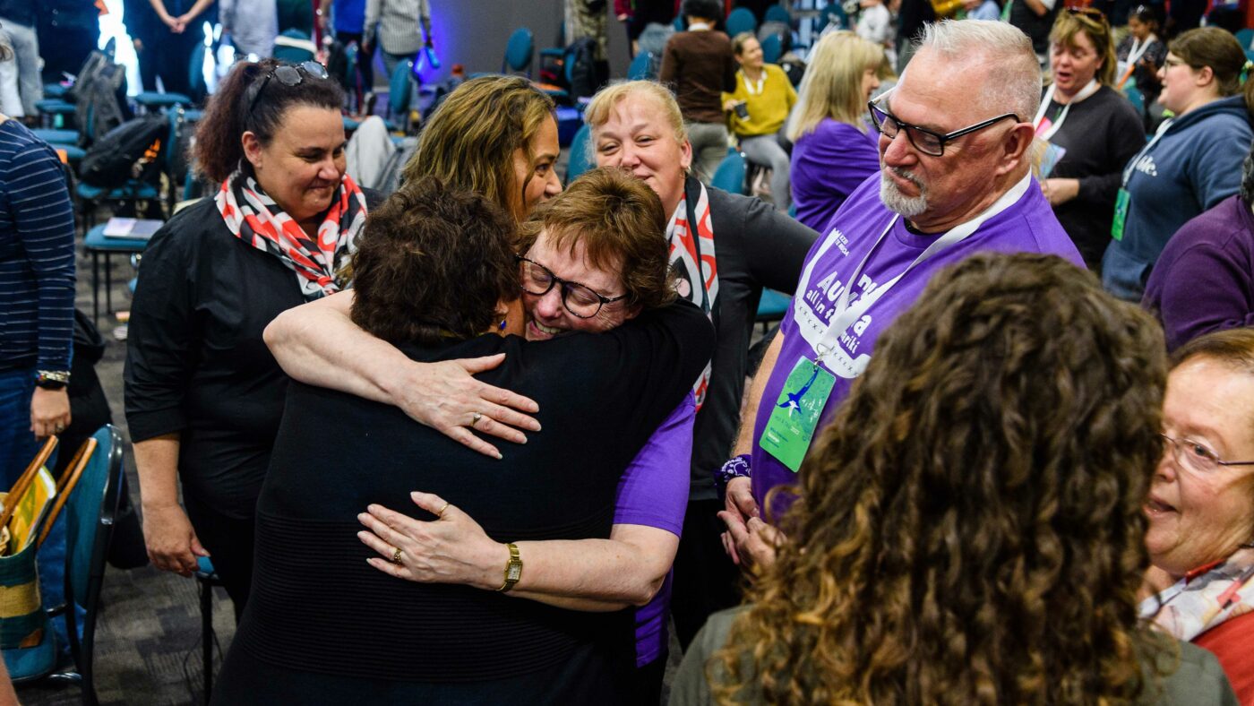 Two members hugging amongst a group at Hui-ā-tau 2022.