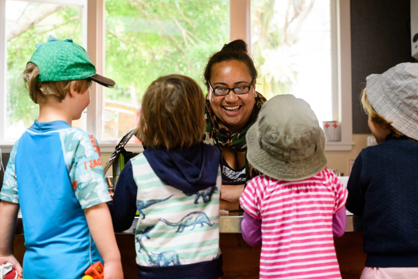 ECE teacher with a group of children standing in front of her.