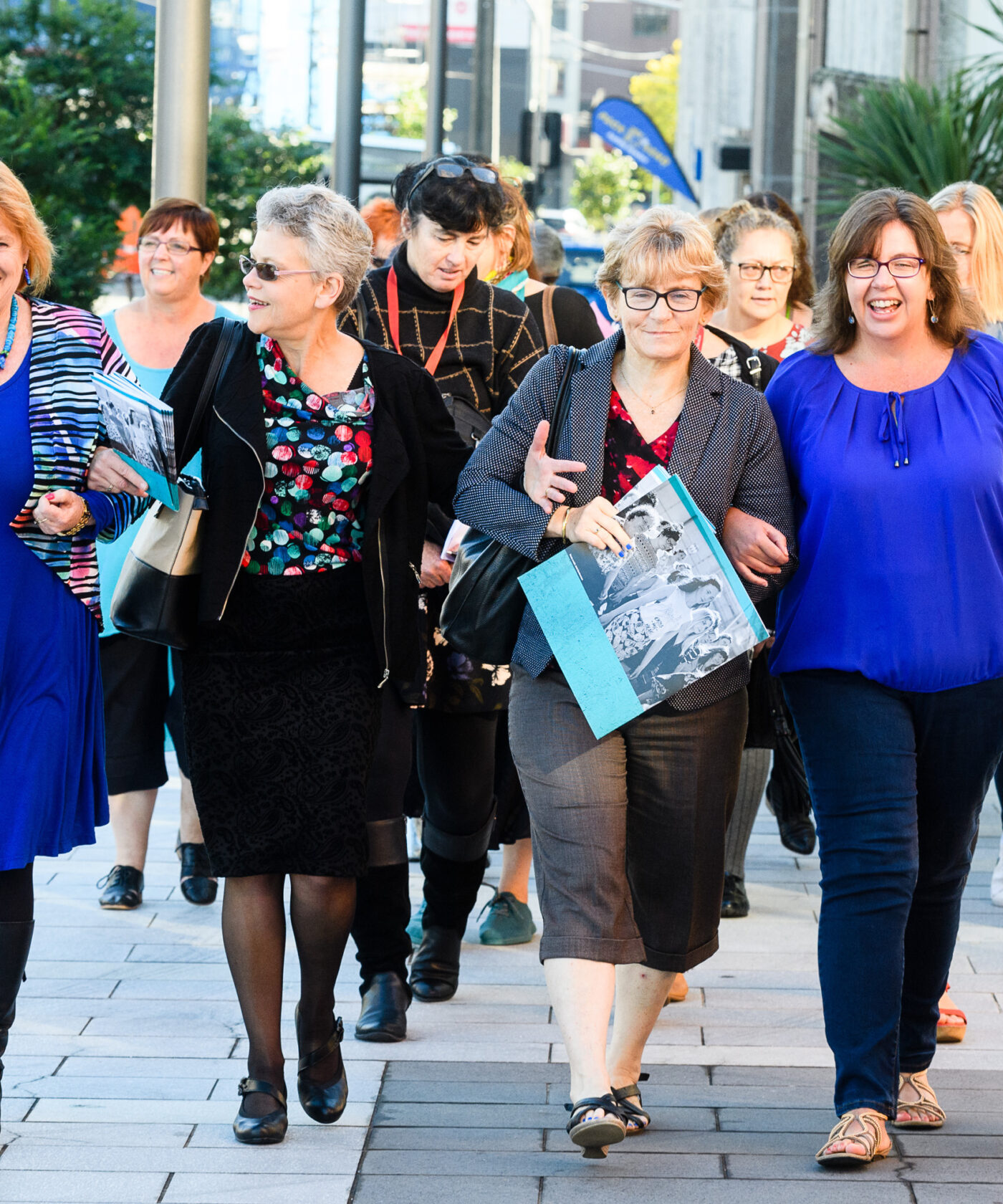 A group of members walking down a street, arm in arm.