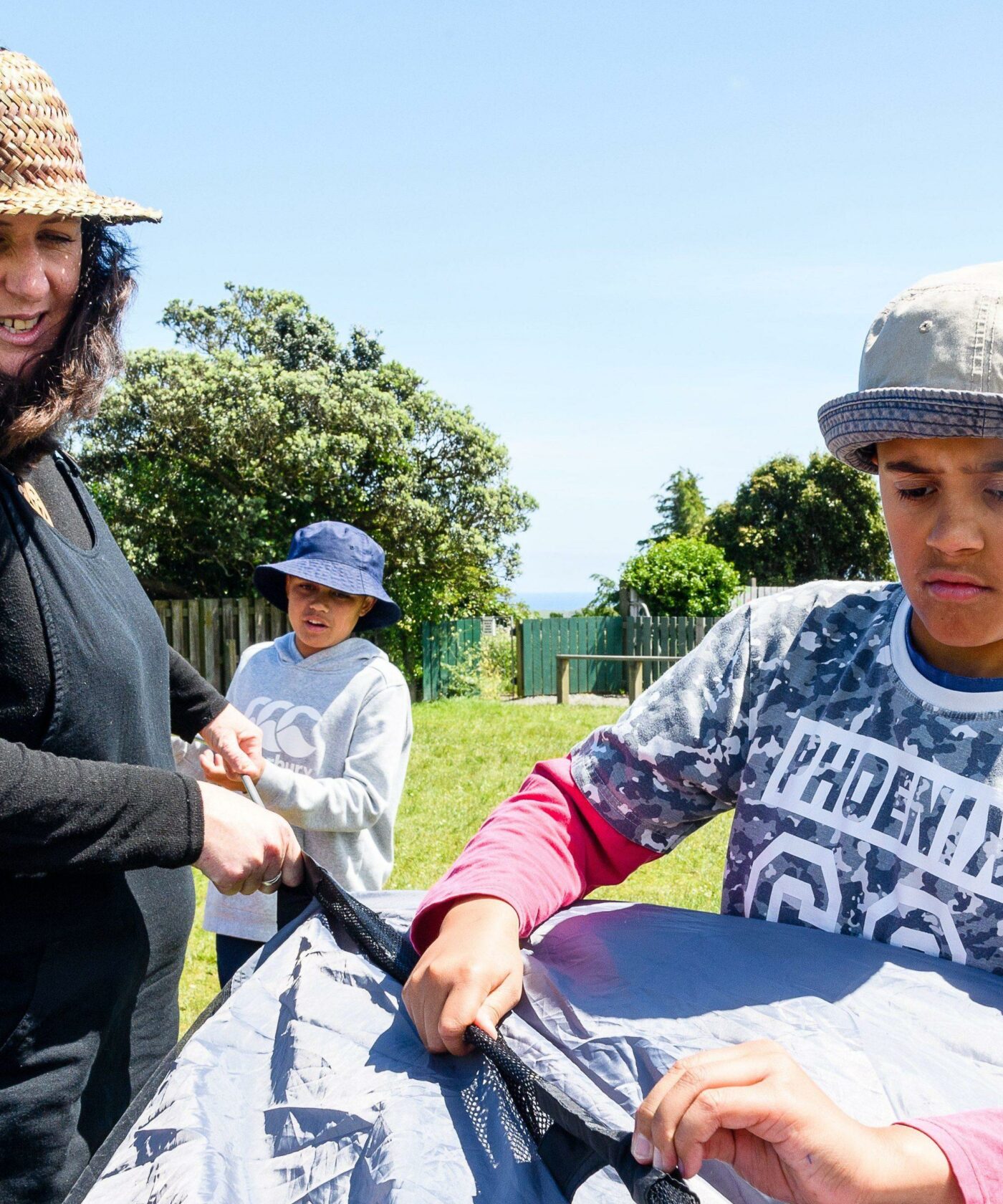 Primary teachers helps students set up a tent.