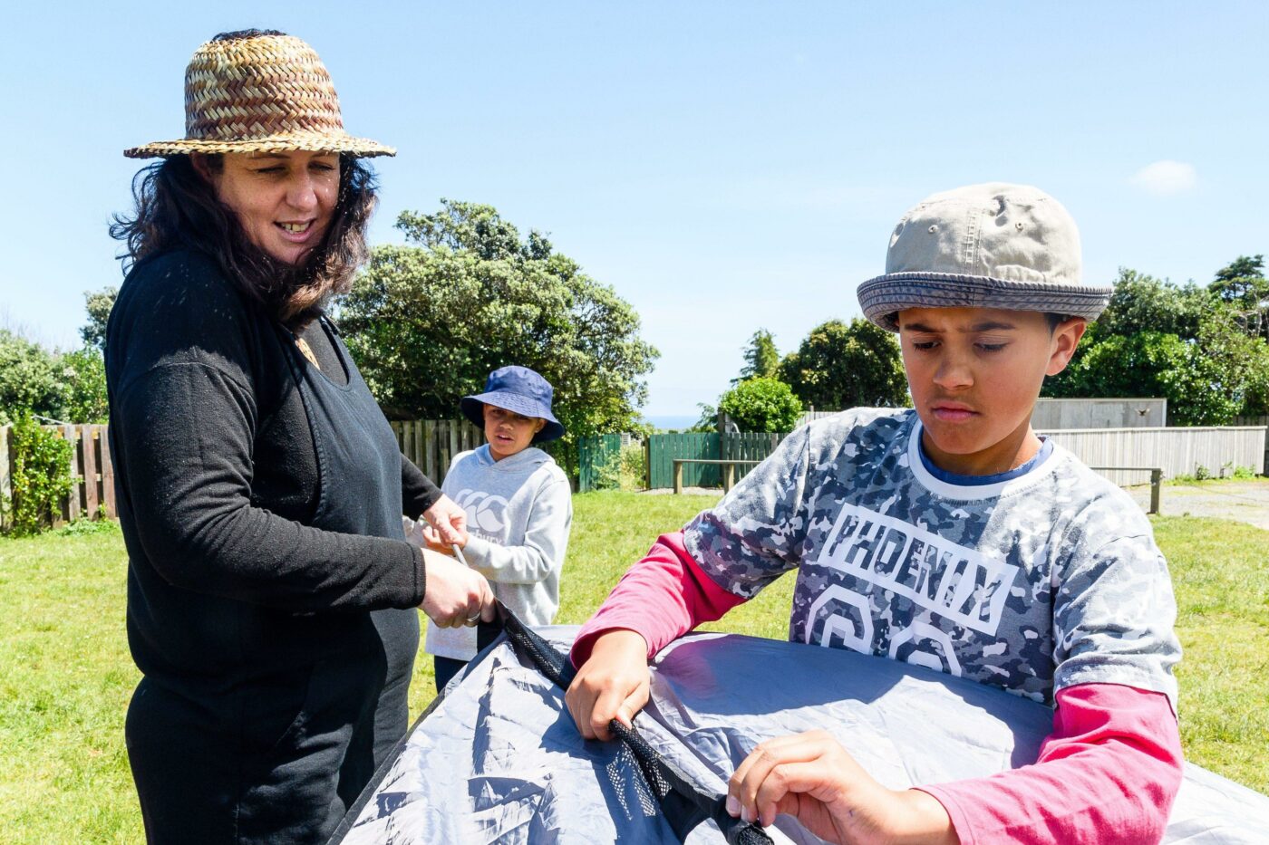 Primary teachers helps students set up a tent.